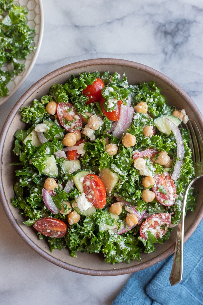 bowl of lemony kale salad with feta cheese and chickpeas