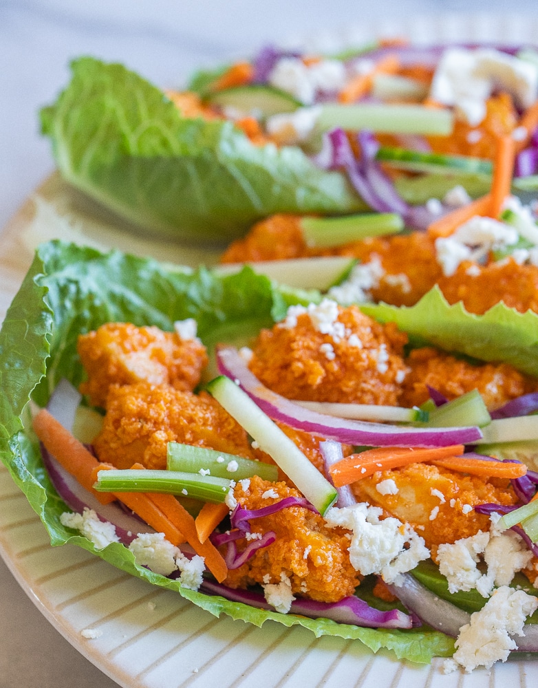 close up of a buffalo tofu lettuce wrap with lots of toppings