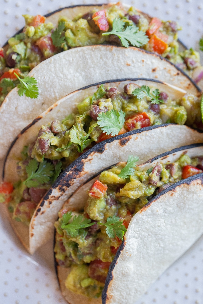 close up of vegetarian loaded guacamole tacos on a plate