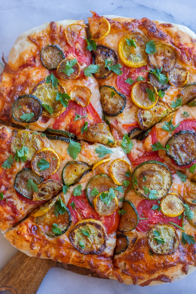summer squash and tomato pizza cut up into slices