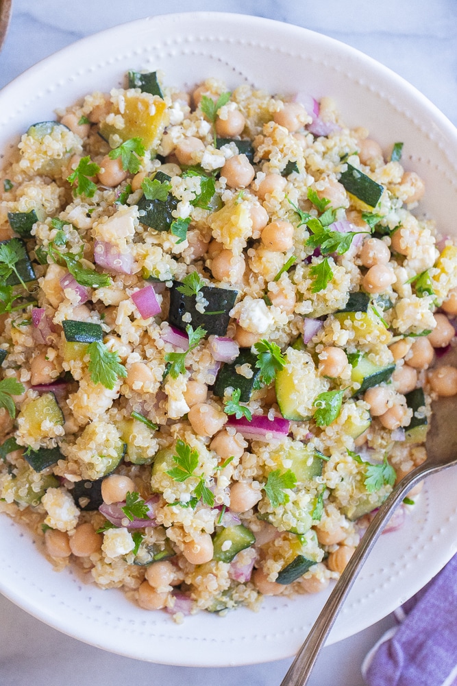 zucchini chickpea quinoa salad in a bowl with a spoon