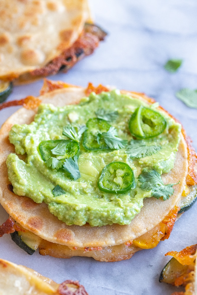 close up of a summer squash quesadilla with guacamole