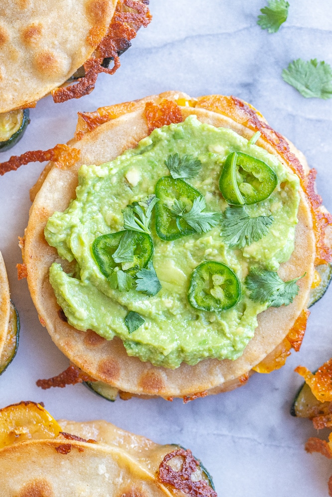 corn and zucchini quesadilla topped with guacamole, jalapenos and cilantro