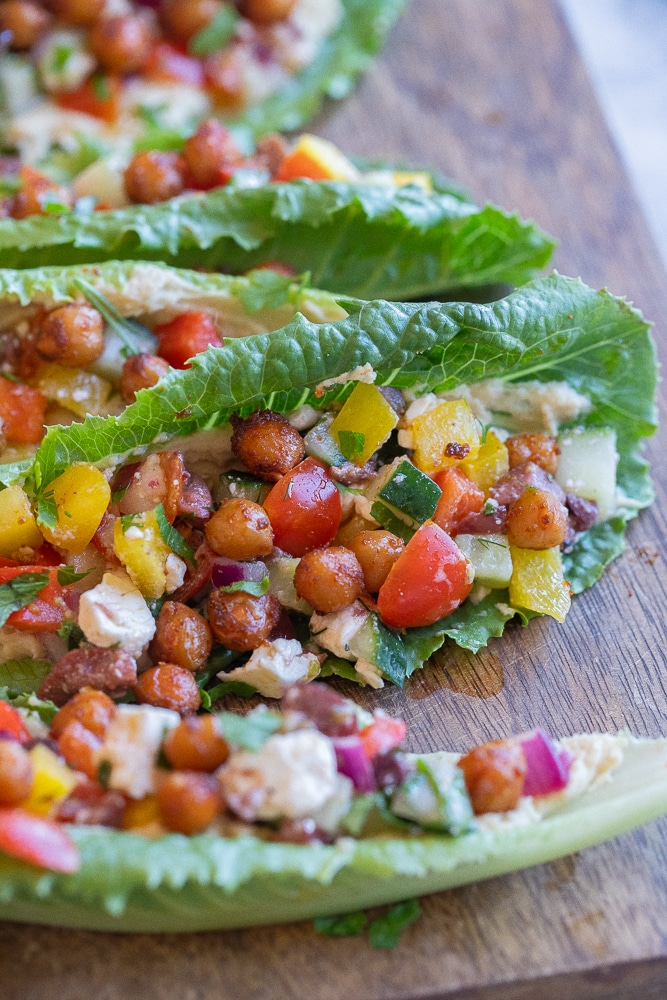 close up of a greek salad lettuce wrap with hummus