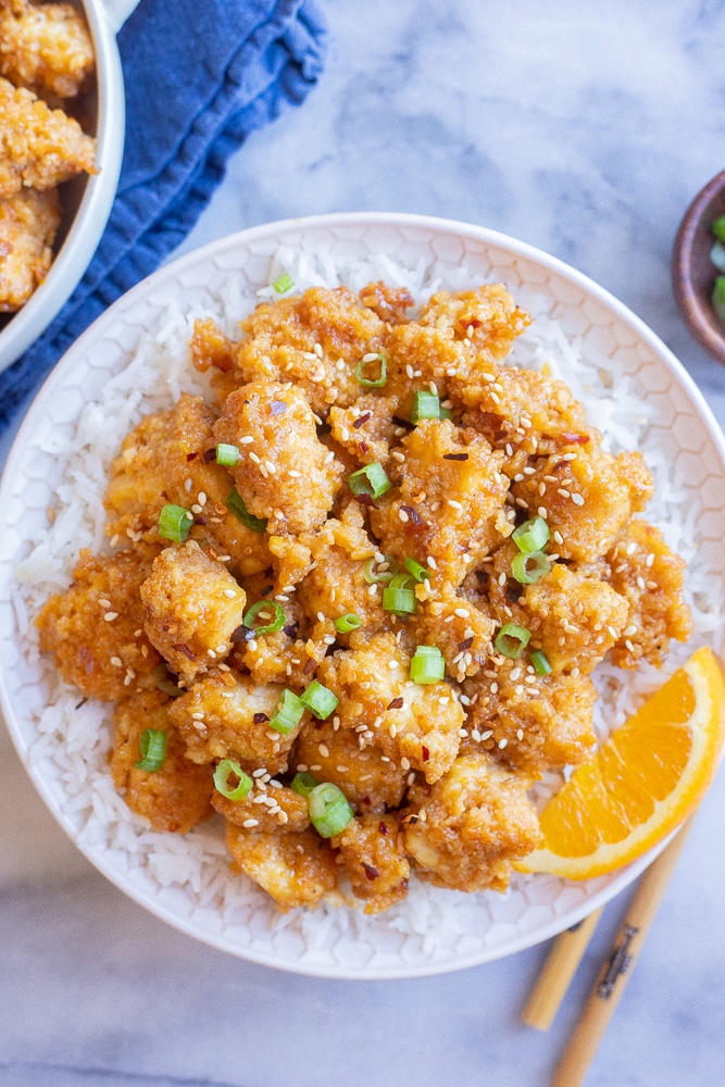 a bowl full of spicy orange ginger tofu on a bed of rice