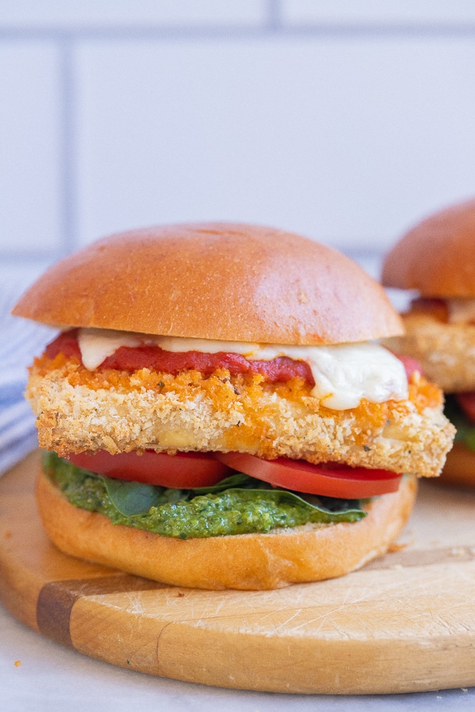 close up of a vegetarian chicken parmesan sandwich on a cutting board