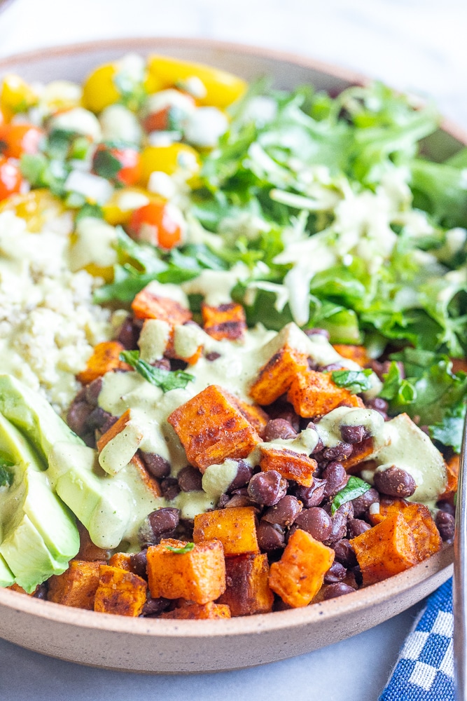 close up of roasted sweet potatoes and black beans in a bowl with quinoa