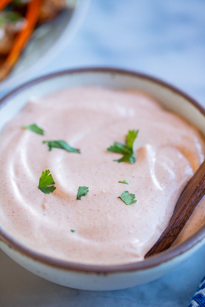 a bowl of fish taco sauce with cilantro garnish