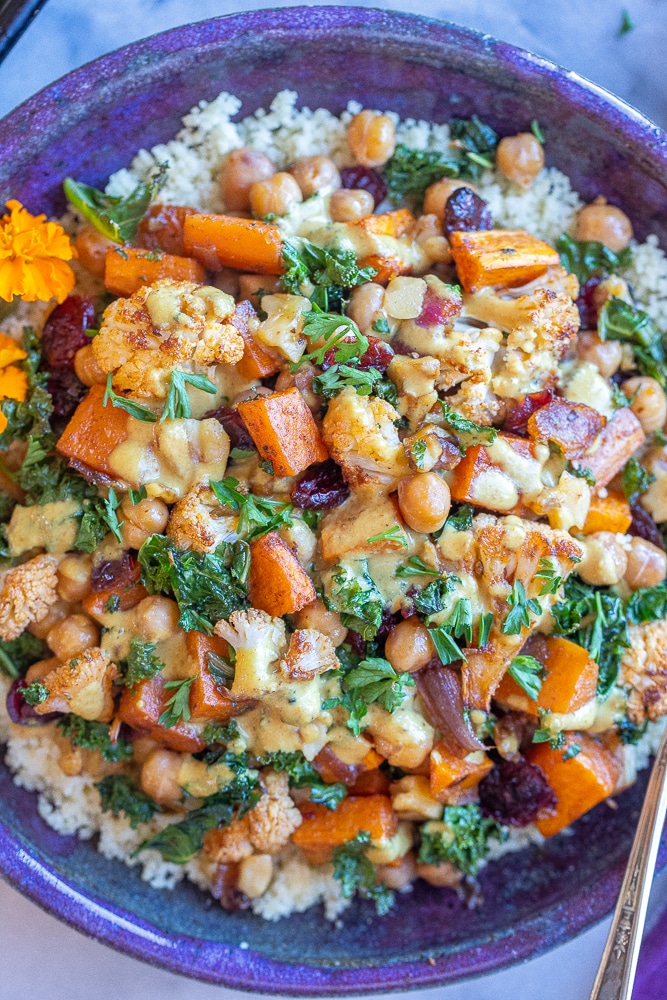 close up of roasted cauliflower and sweet potato bowls with kale and curry tahini dressing
