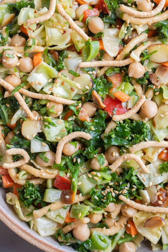 close up of asian kale and cabbage salad with peanut dressing in a bowl