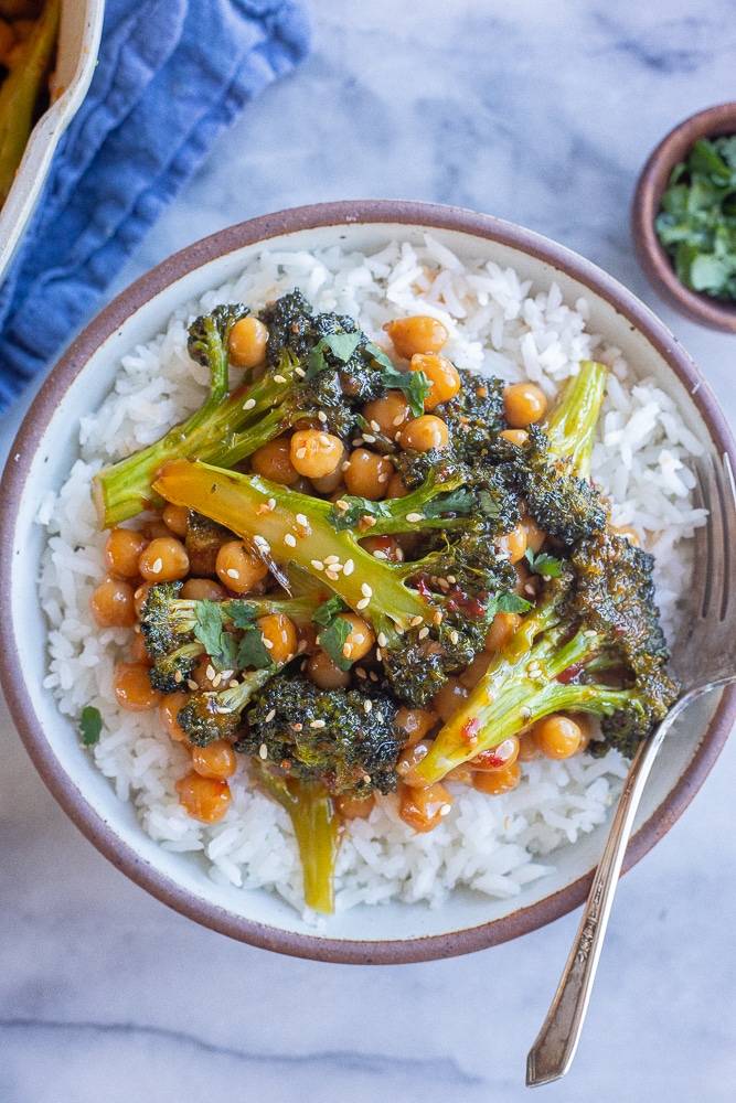 chili garlic broccoli with chickpeas in a bowl with a fork
