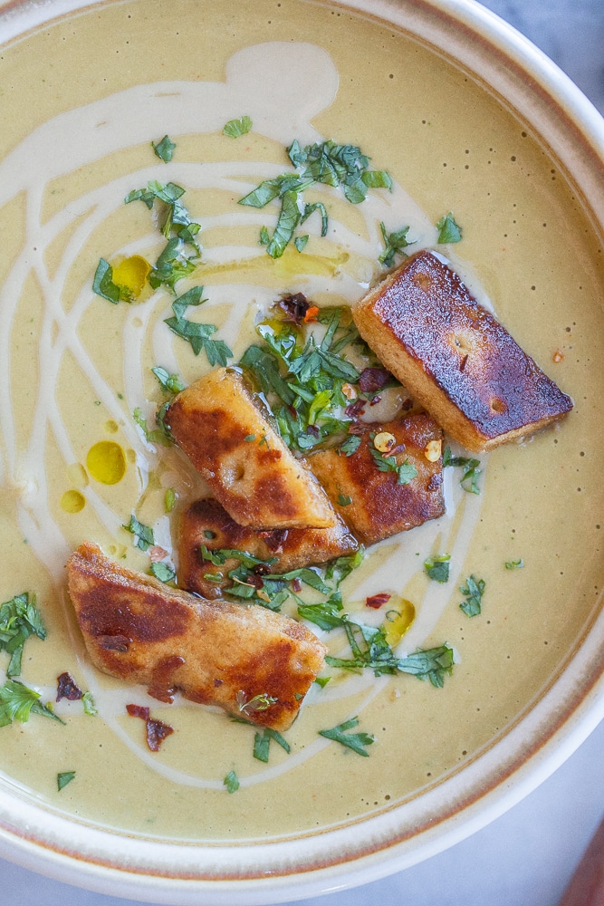 close up of this 30 minute falafel soup topped with tahini and fresh herbs