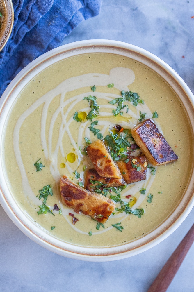 bowl of falafel soup topped with crispy pita bread