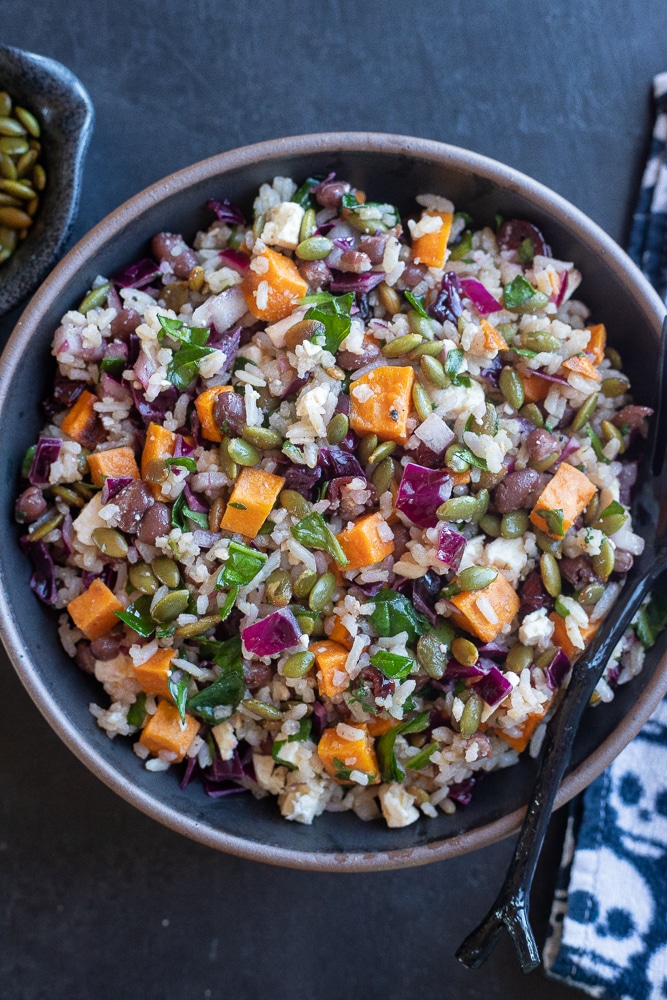 Halloween Salad with Rice and Veggies in a black bowl on a black table
