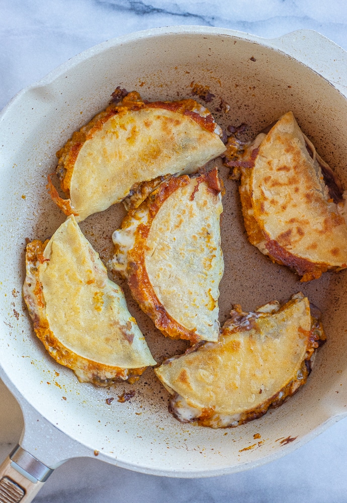 vegetarian tacos with pumpkin and black beans in a frying pan