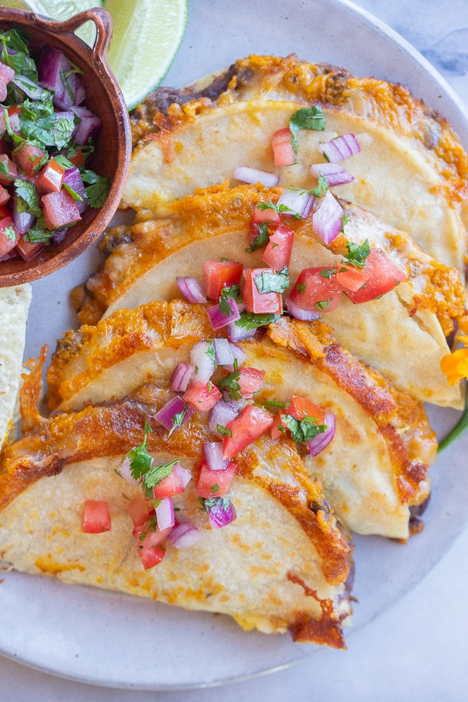 a plate full of pumpkin and black bean tacos topped with pico de Gallo