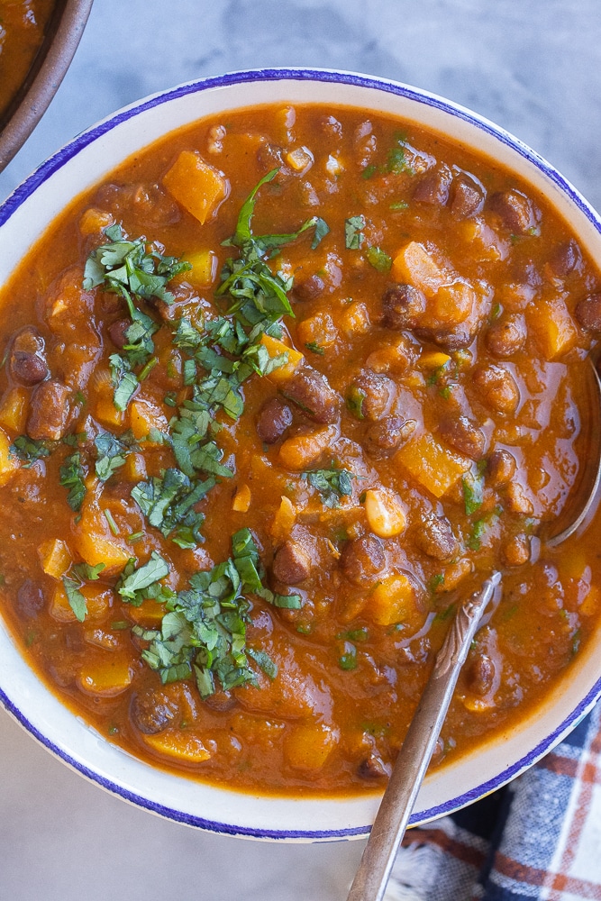 close up of pumpkin chili in a bowl with a spoon