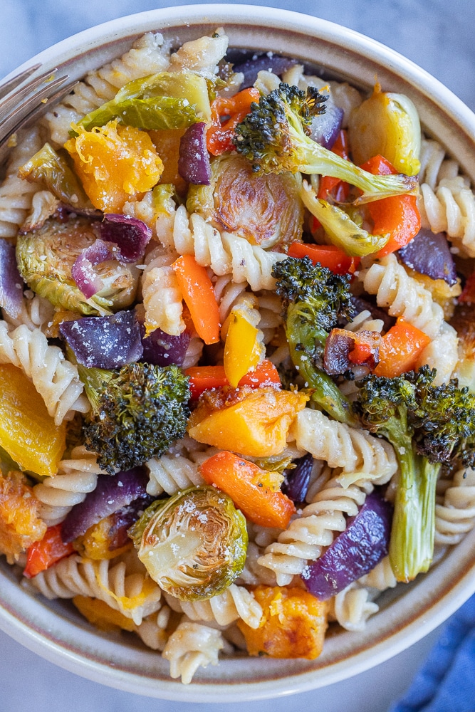 close up of a bowl of rainbow veggie pasta with parmesan cheese