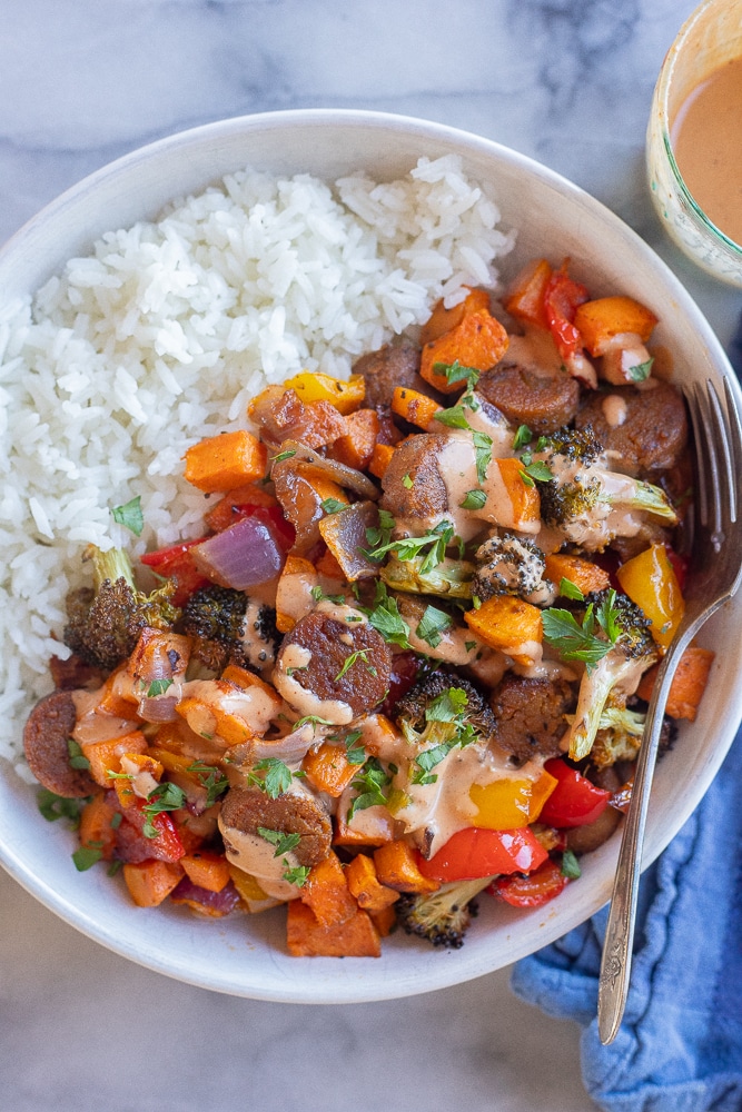 dinner bowl of this easy vegetarian sheet pan dinner with sausage and veggies with rice and bbq sauce
