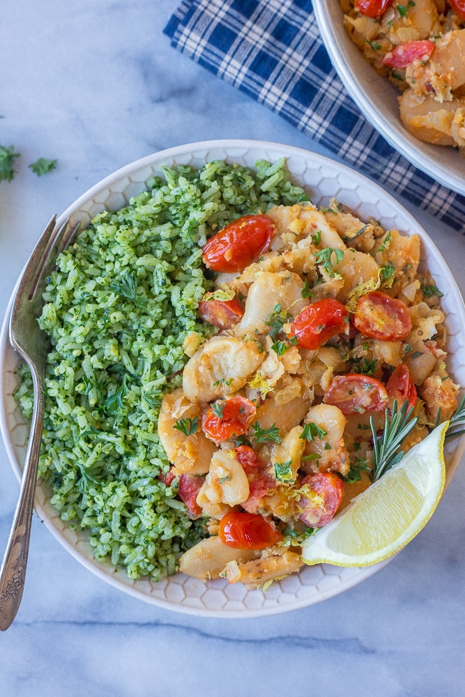 bowl with green pesto rice and butter beans with tomatoes and herbs