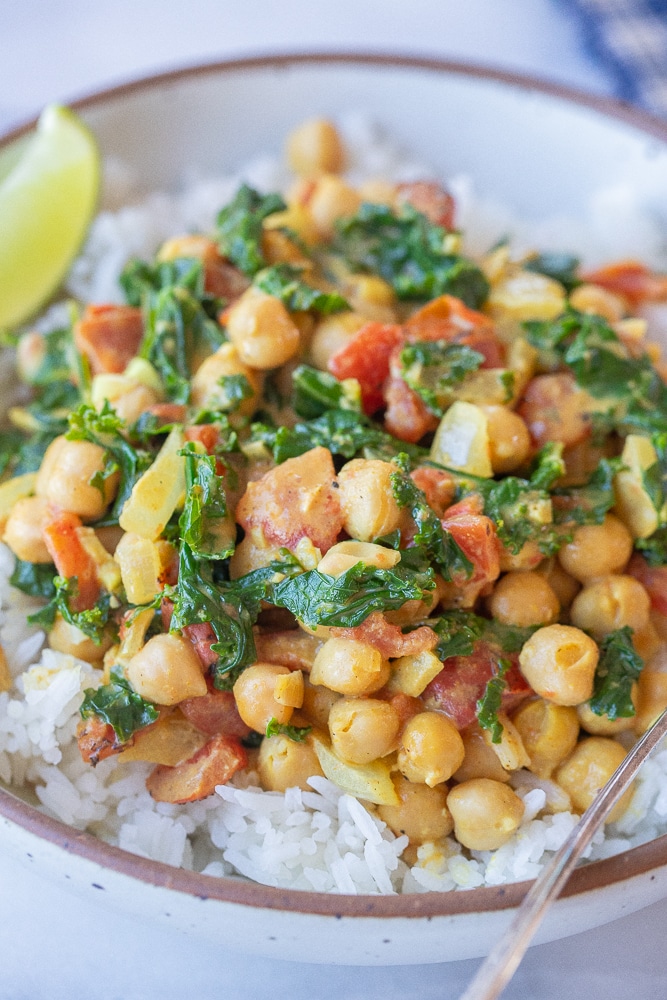close up of a bowl of hearty chickpea curry with kale