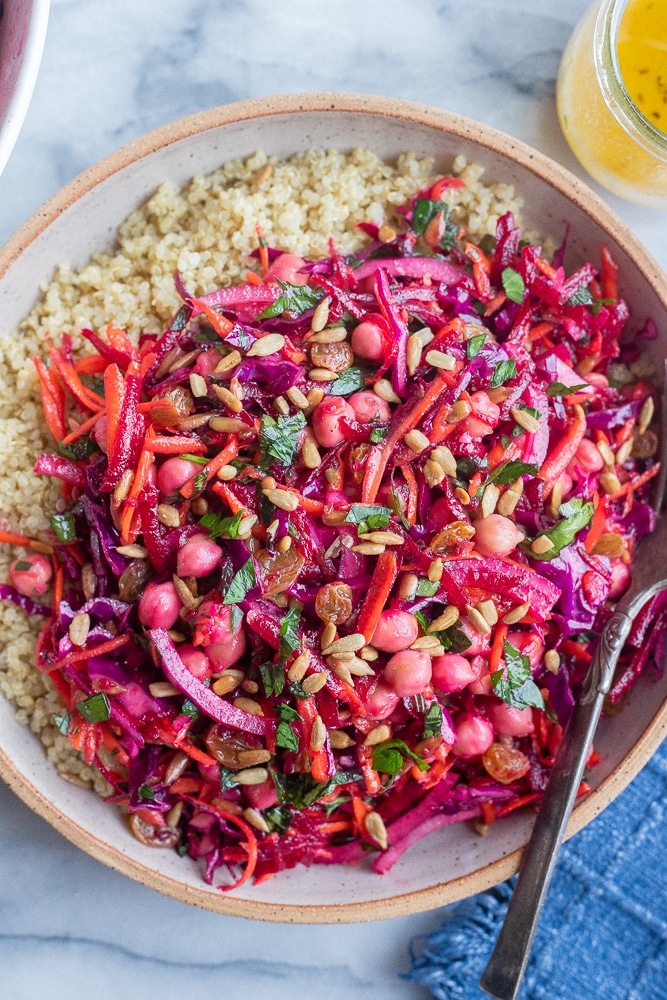 a bowl of beet and carrot salad with chickpeas in a bowl with quinoa