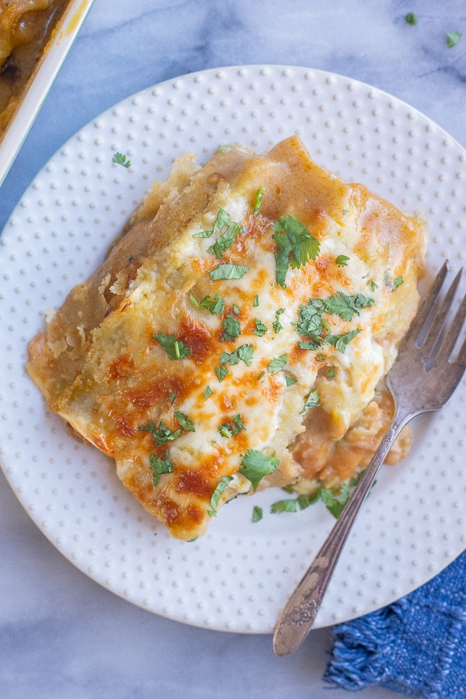 plate filled with two vegetarian green Chile enchiladas with melted cheese