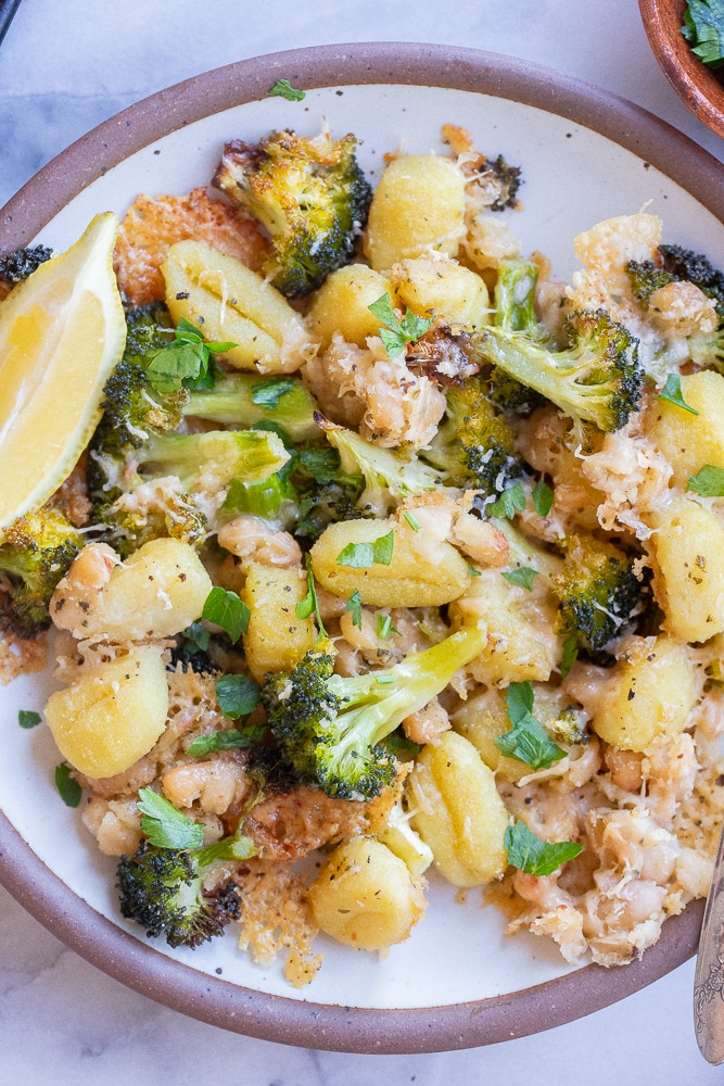 Plate of crispy parmesan gnocchi with broccoli and white beans