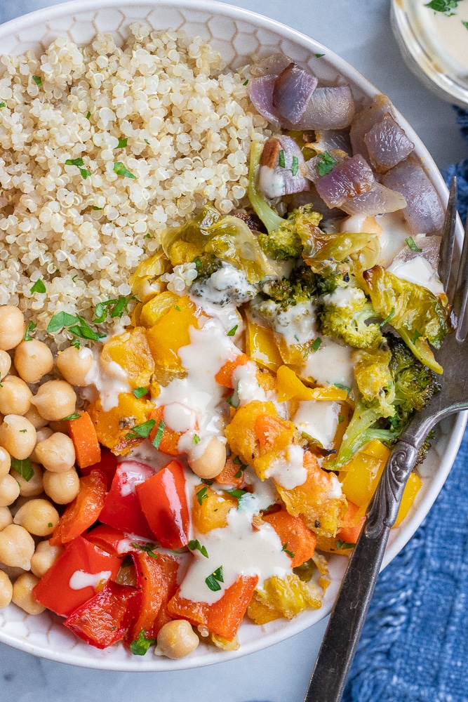 close up of rainbow colored vegetables in a bowl with quinoa and chickpeas
