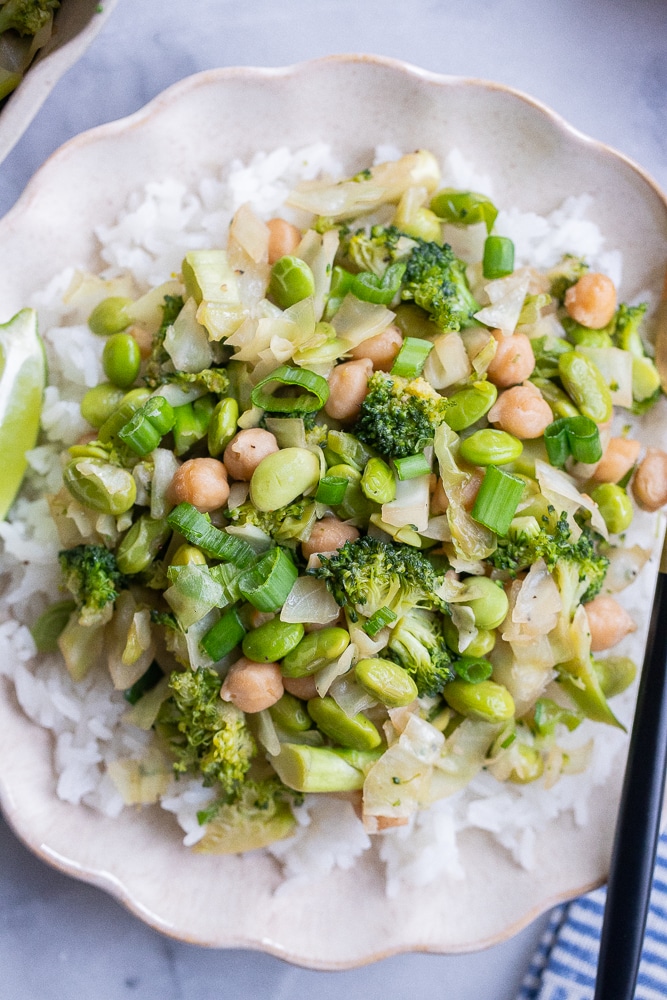 bowl of green veggie stir fry with chickpeas over rice