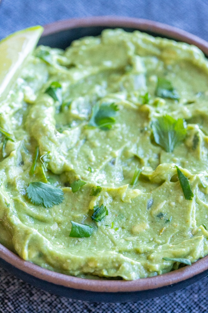 close up of a bowl of easy guacamole topped with cilantro