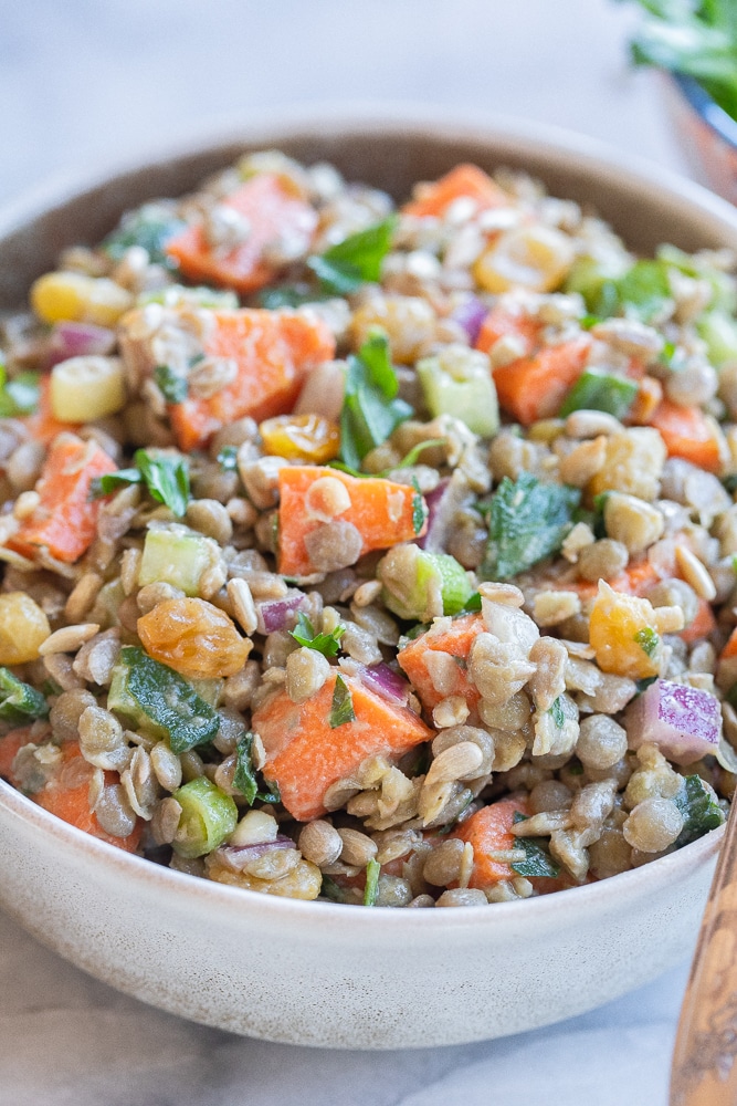 close up of a bowl of meal prep lentil and roasted carrot salad