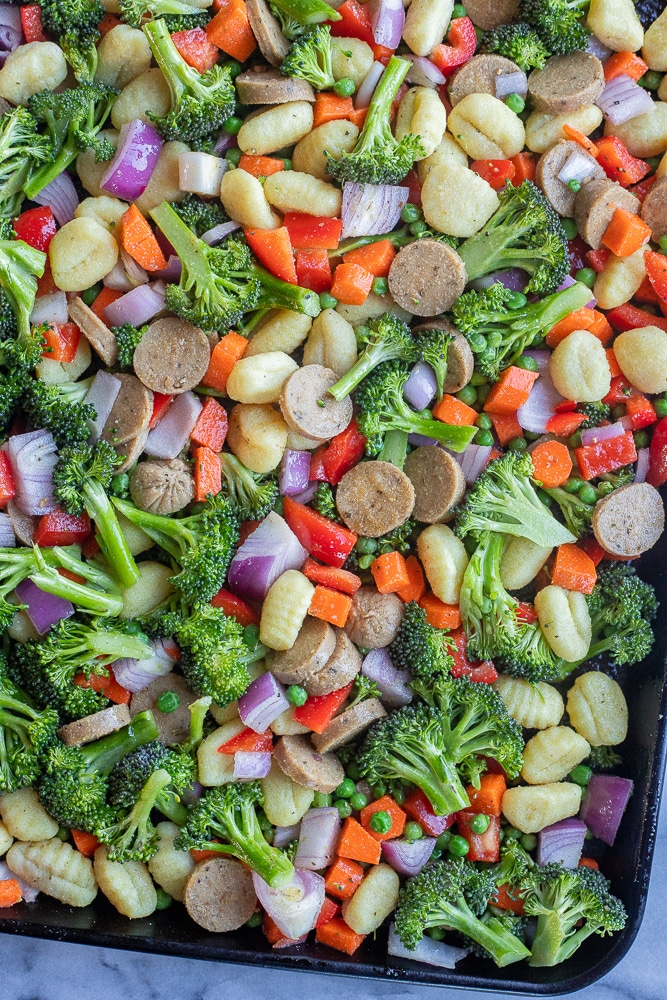 vegetarian sheet pan dinner with gnocchi, sausage and vegetables on a baking tray