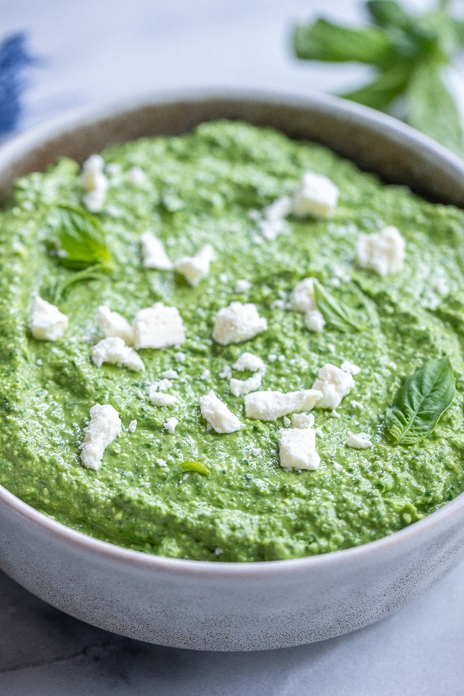bowl full of basil pesto with spinach and feta cheese