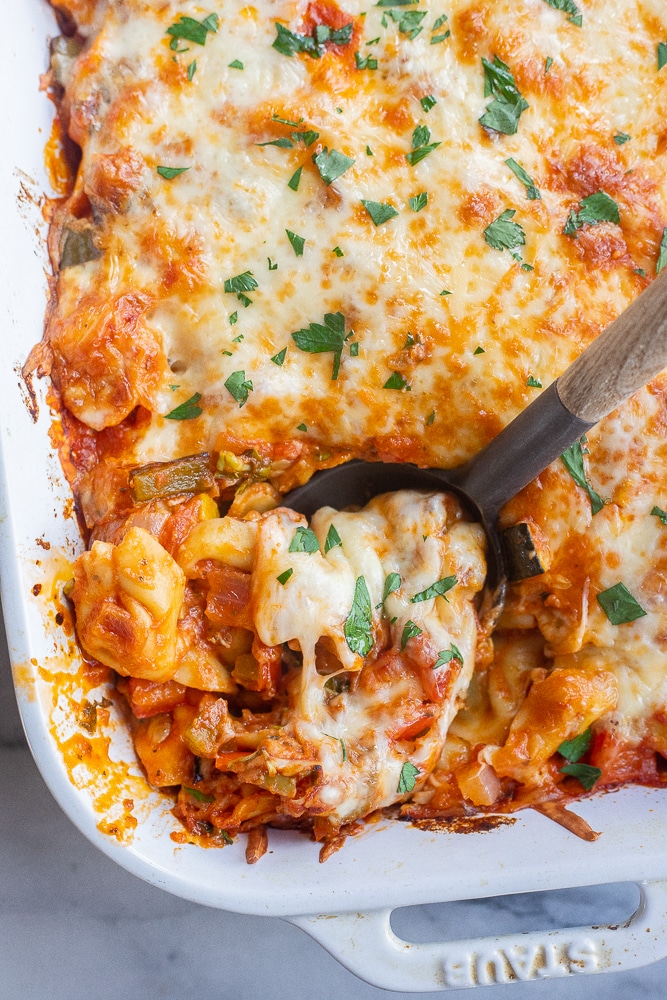 cheesy tortellini bake with a serving spoon