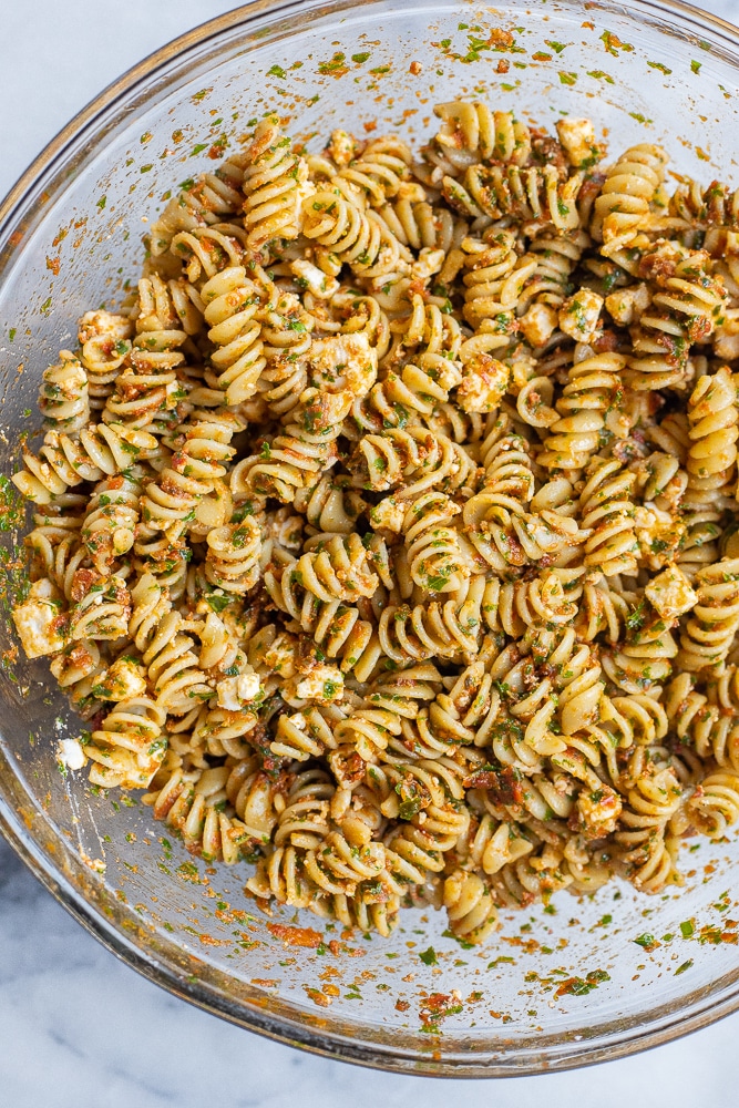 serving bowl full of kale and sun-dried tomato pasta with feta cheese