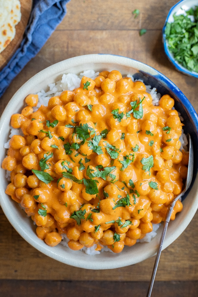 bowl of red curry chickpeas with rice and cilantro