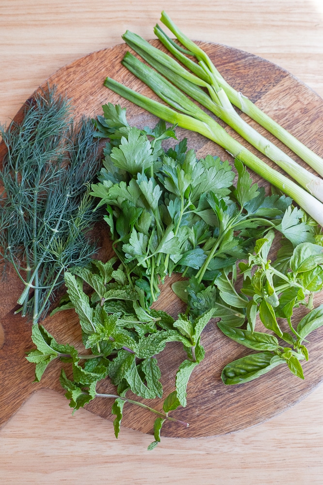 Fresh herbs on a cutting board for the green goddess dressing