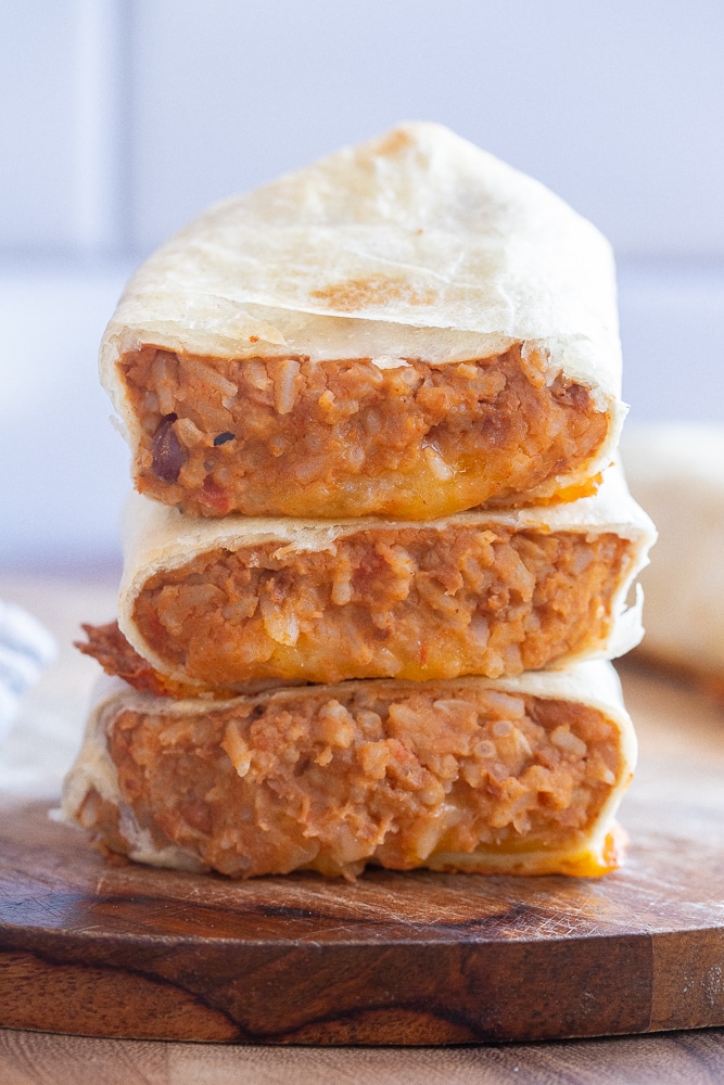 3 vegetarian bean burritos stacked on top of eachother