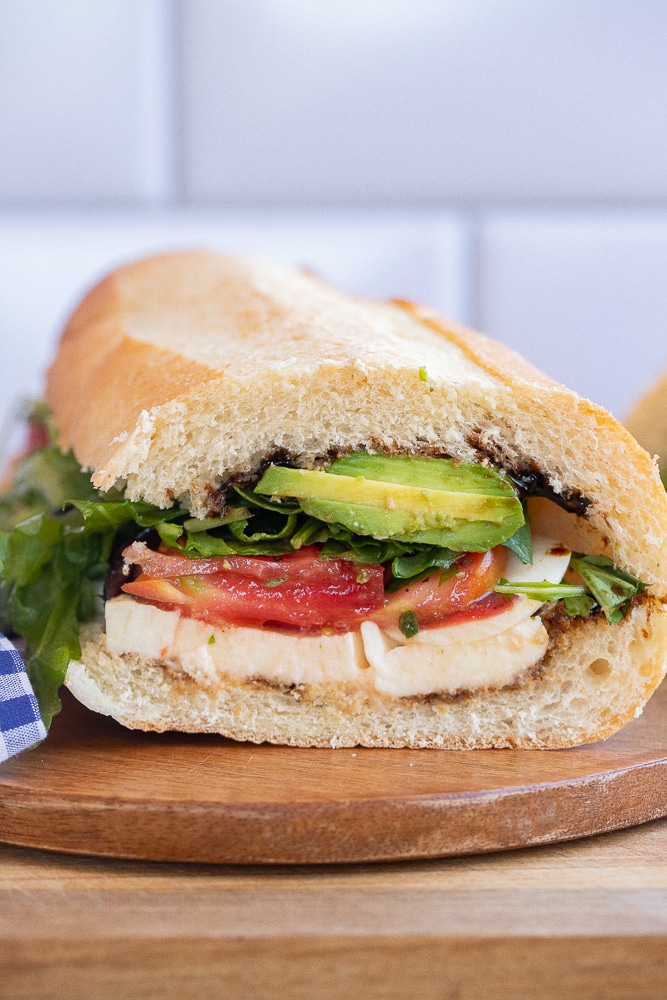 close up of an avocado caprese sandwich that has been cut in half
