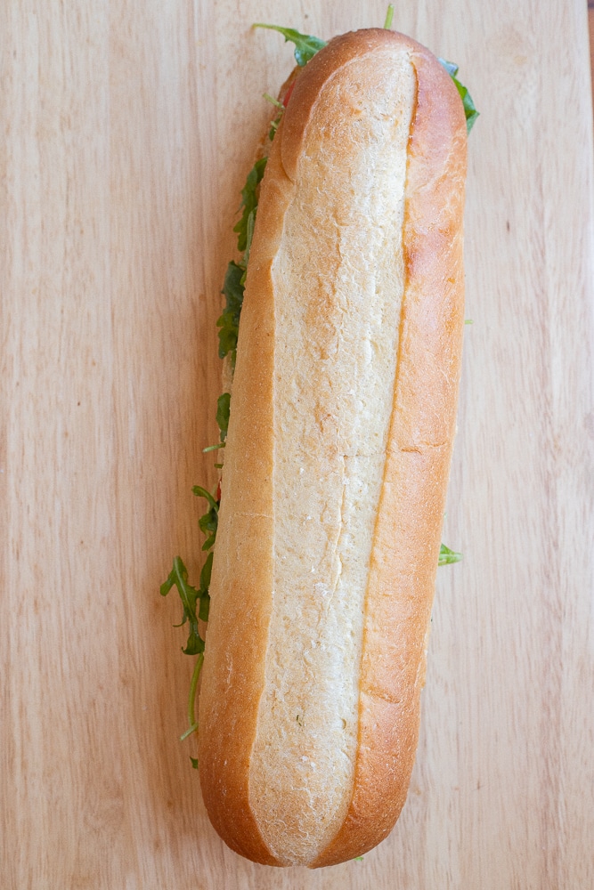 avocado caprese hoagie sandwich on a cutting board