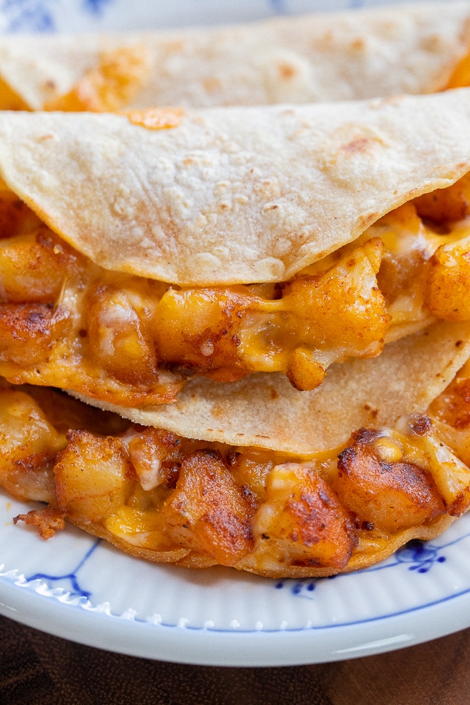 close up of a cheesy cauliflower and potato taco on a plate