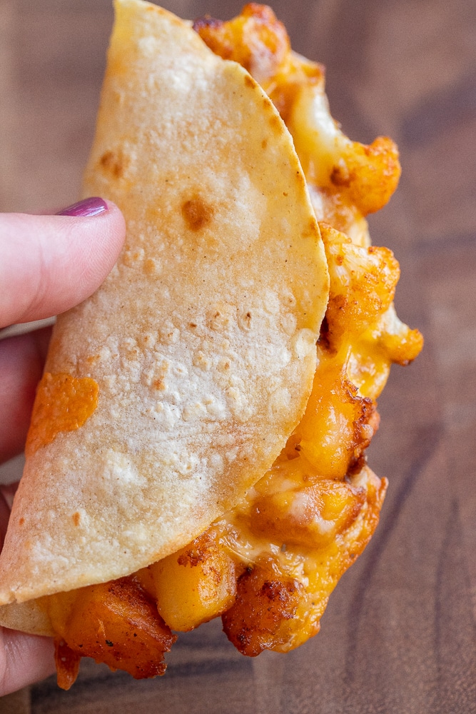 close up of a hand holding a crispy cauliflower taco