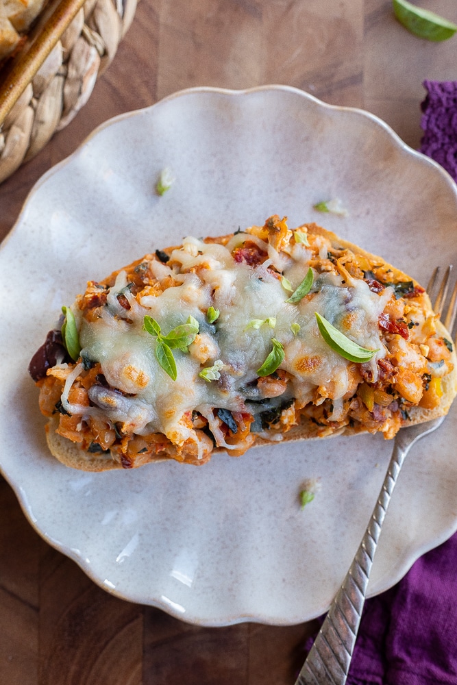 tuscan white bean toast on a plate with a fork