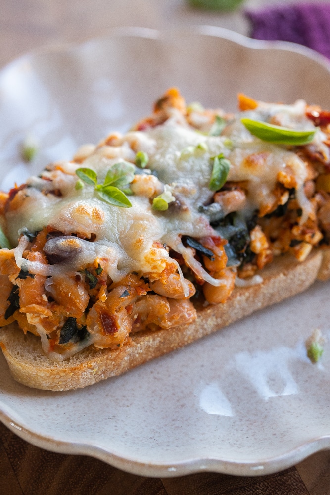 Close up of Tuscan white beans on toast with melted cheese