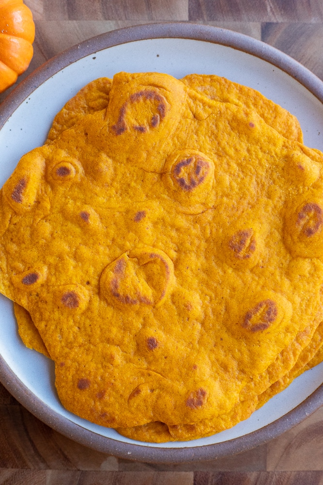 plate with four pumpkin flatbreads on it