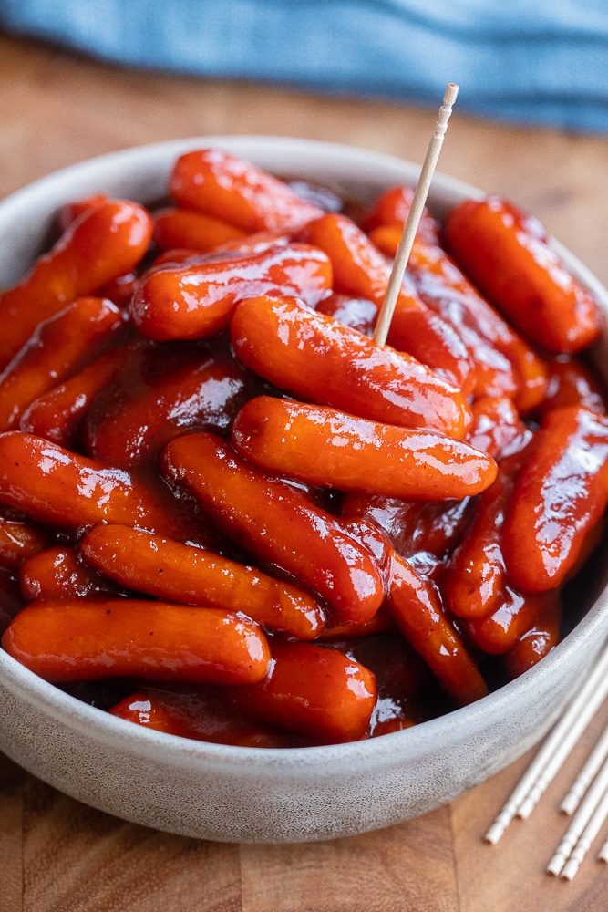 close up of a bowl filled with baby carrot little smokies