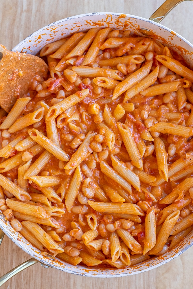large pan full of tomato and white bean pasta