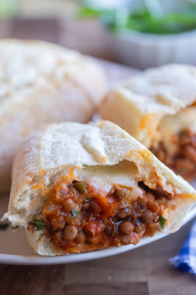 close up of half of a lentil subs sandwich on a plate