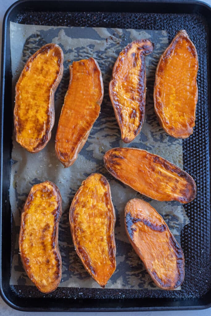 Roasted sweet potato halves on a baking sheet